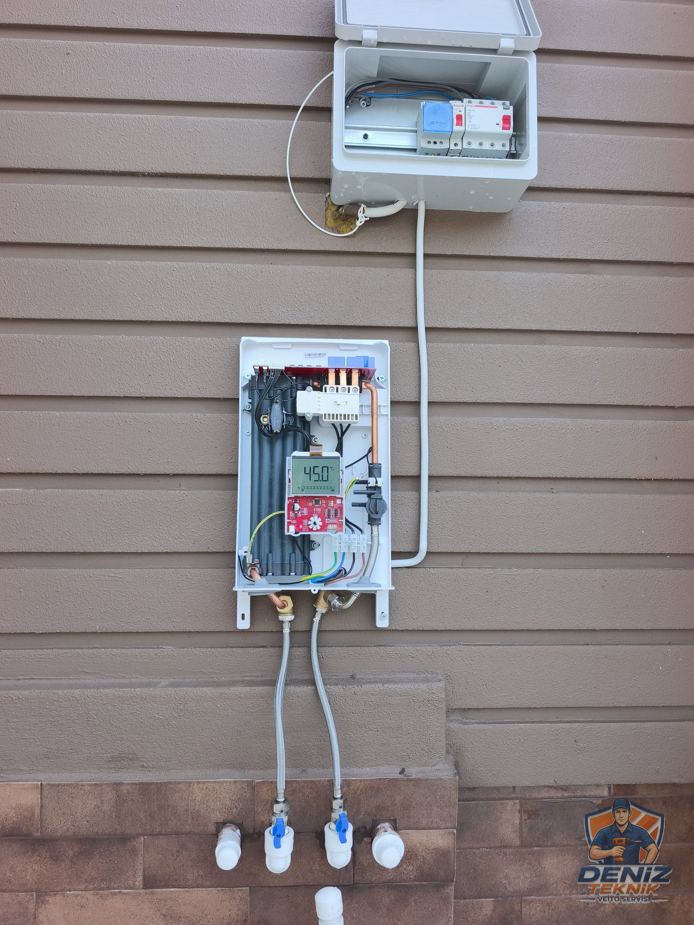 Veito Blue-S dış cephede kombi tesisatı yerine, kapağı açık; ekran 45 °C, elektrik ve su bağlantıları tamamlanmış