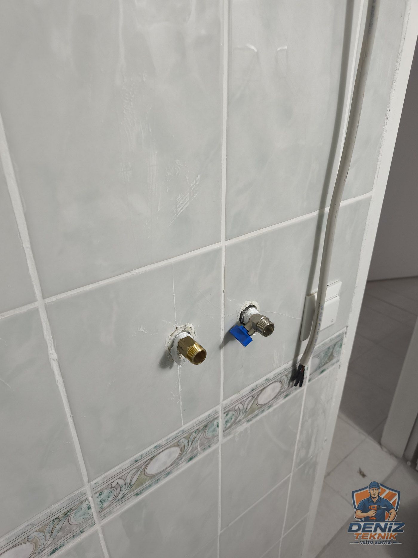 Fayanslı duvarda kör tapa uçlarına rakor ve vana takılmış, elektrik kablosu yanda hazır